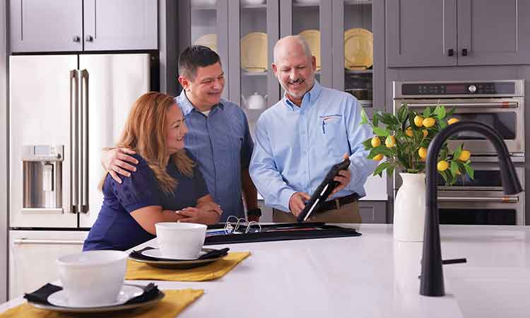 A David Weekley Homes Warranty Representative talks with homeowners while standing in a kitchen