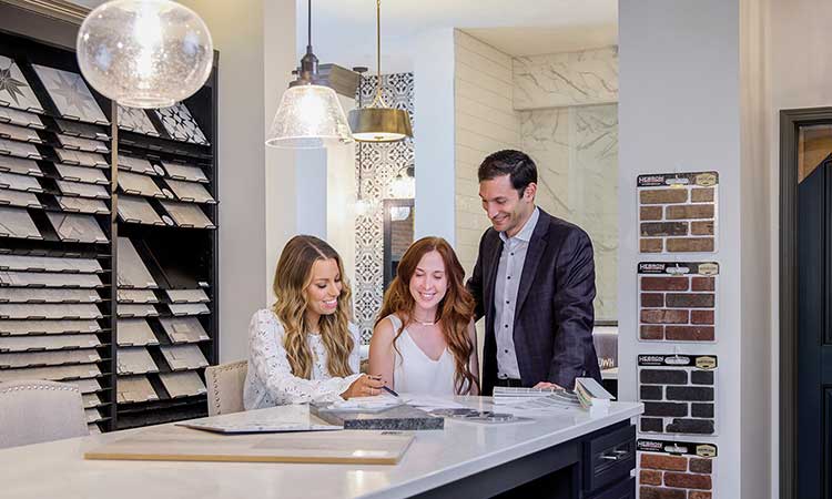 A David Weekley Homes Design Consultant showing customers kitchen options