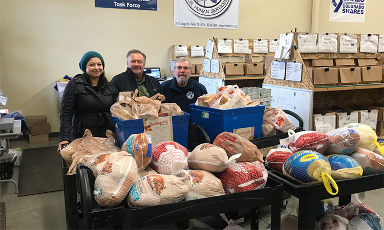 David Weekley Homes Team Members standing with donated frozen turkeys