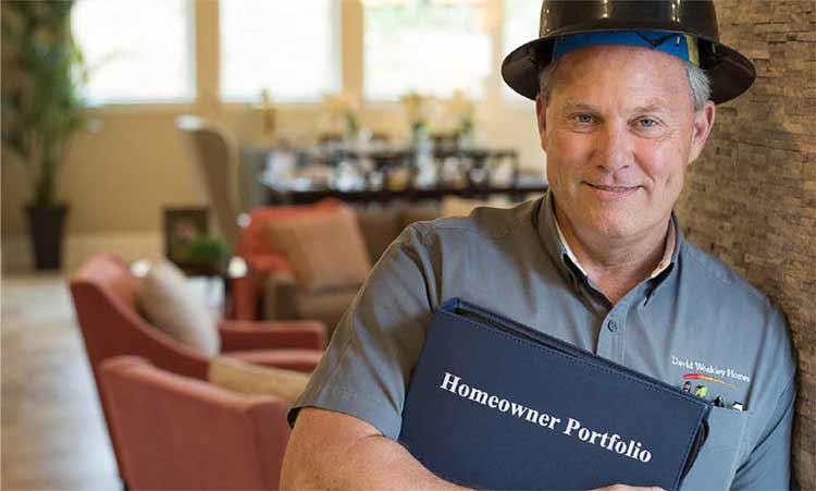 A David Weekley Homes Warranty Representative holds a Homeowner Warranty Portfolio