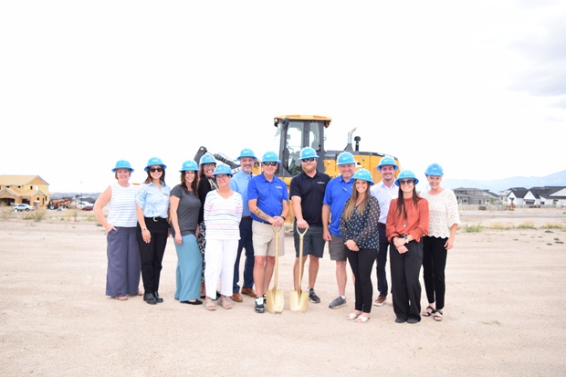 a group of people standing in front of construction equipment and wearing hard hats