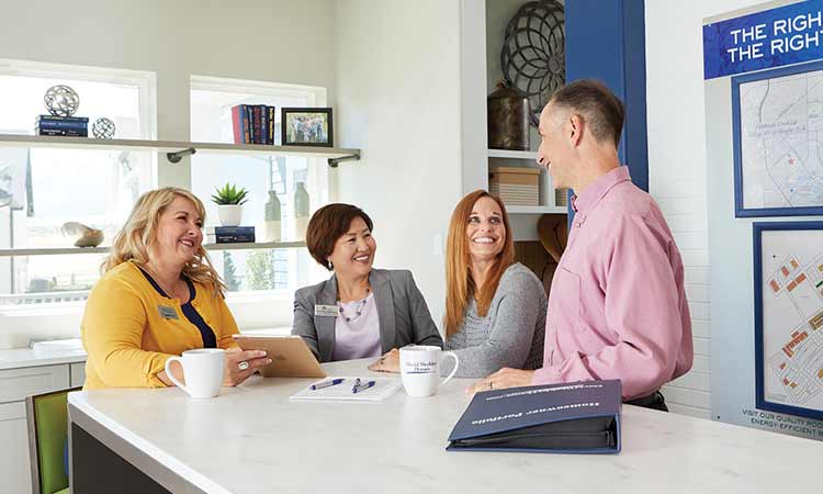 David Weekley Homes Team Members sit at a counter talking