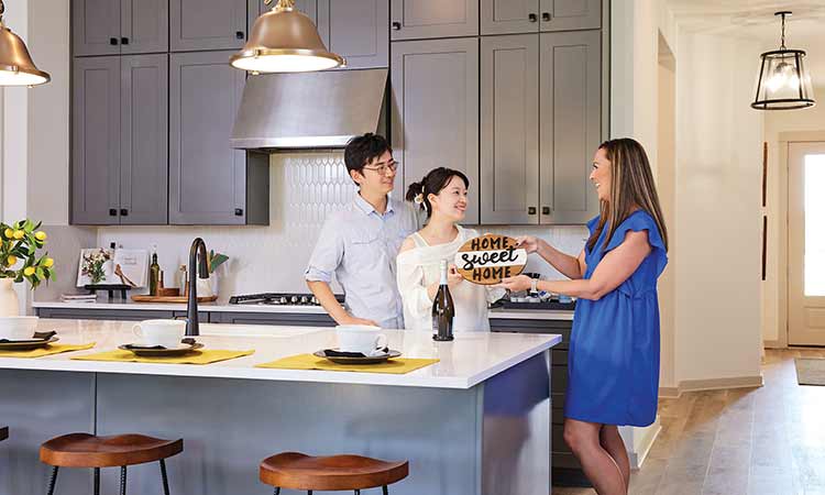 A David Weekley Homes Personal Sales Consultant welcomes two people to their new home