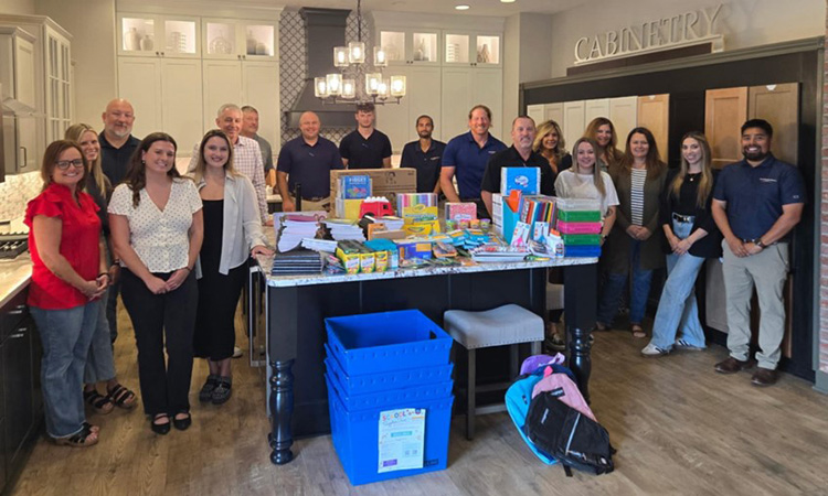 David Weekley Homes Team Members standing with donated school supplies
