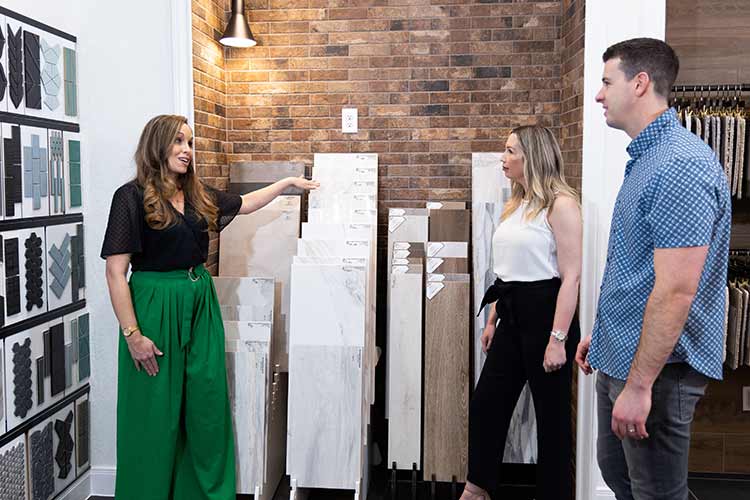 A David Weekley Homes Design Consultant shows flooring samples to cusomters