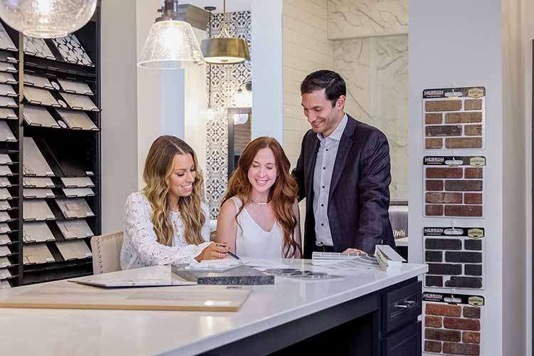 A David Weekley Homes Design Consultant showing customers kitchen options