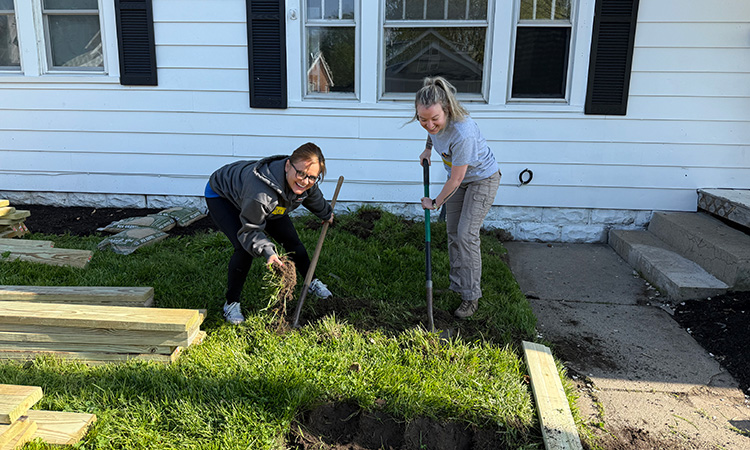 Two David Weekley Homes Team Members gardening