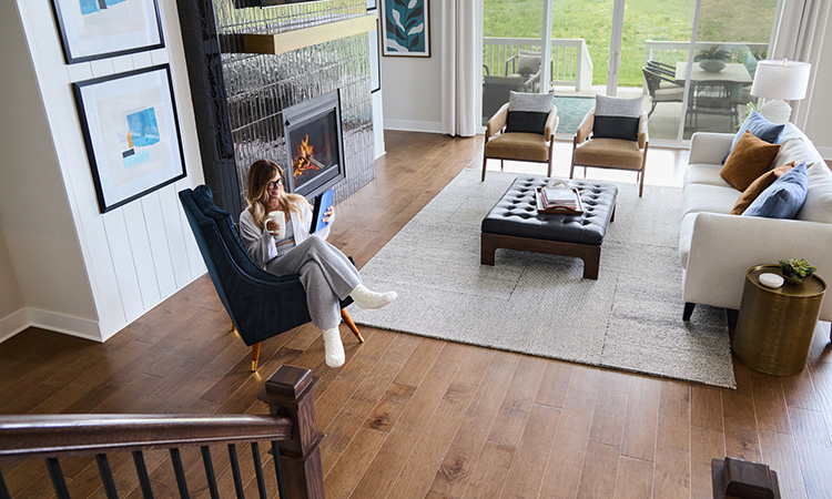 an image of a woman reading while sitting in a chair by a fireplace