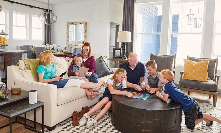 a family sits in a family room reading and playing a board game