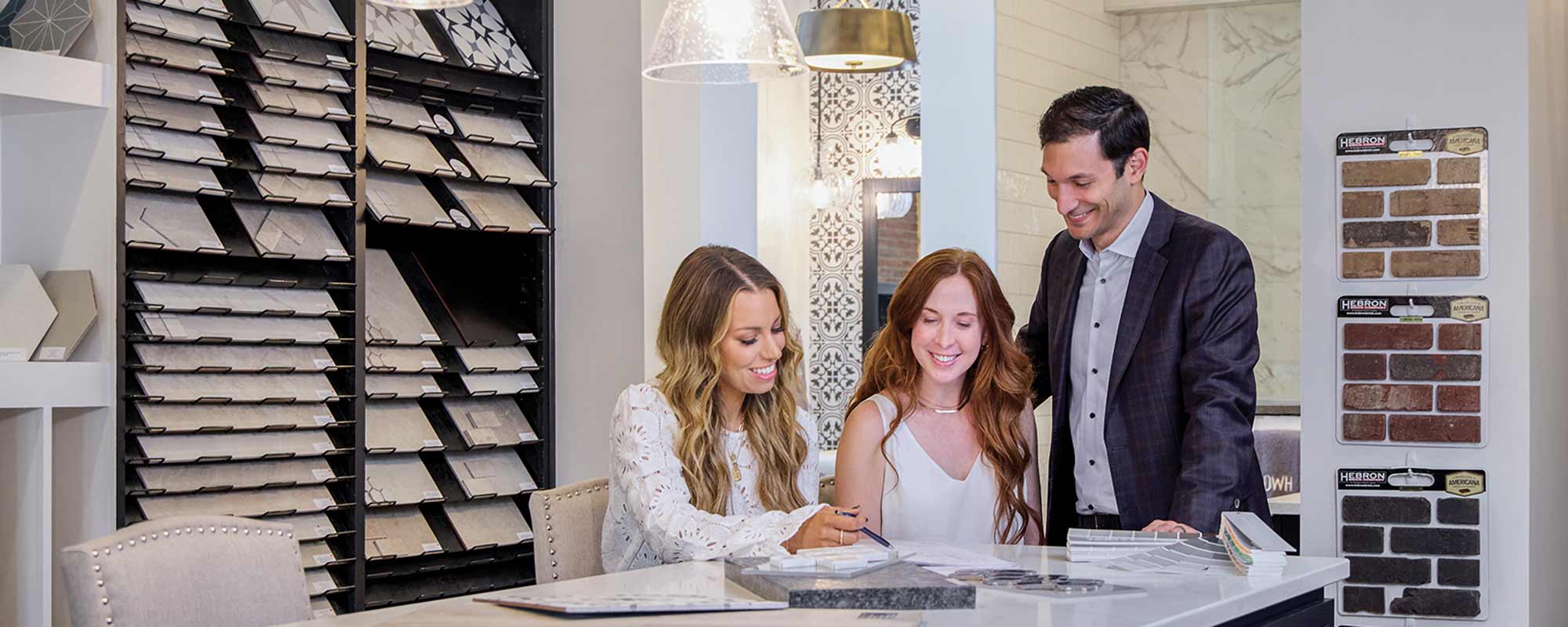 A David Weekley Homes Design Consultant shows two customers countertop samples