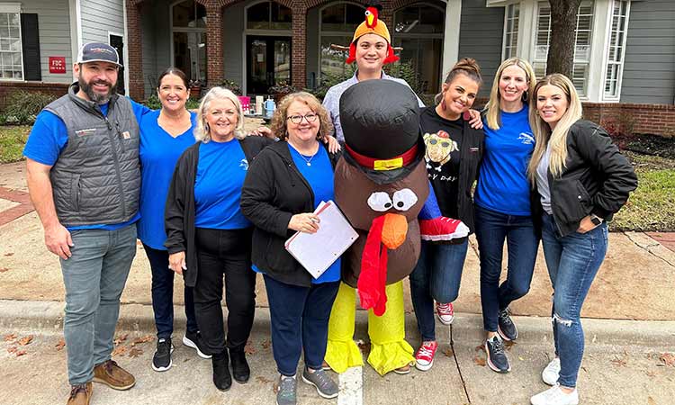 David Weekley Homes Team Members posing with bags of donated food at a past Thanksgiving Drive in Dallas/Ft. Worth, TX