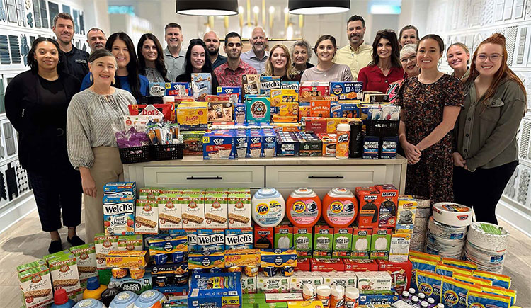Team Members posing with Thanksgiving Drive food donations