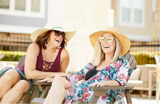 two women sitting poolside and laughing
