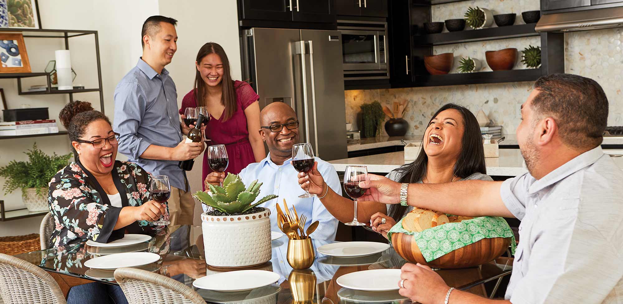 David Weekley Homes Homeowners sitting at a dining table and enjoying glasses of wine