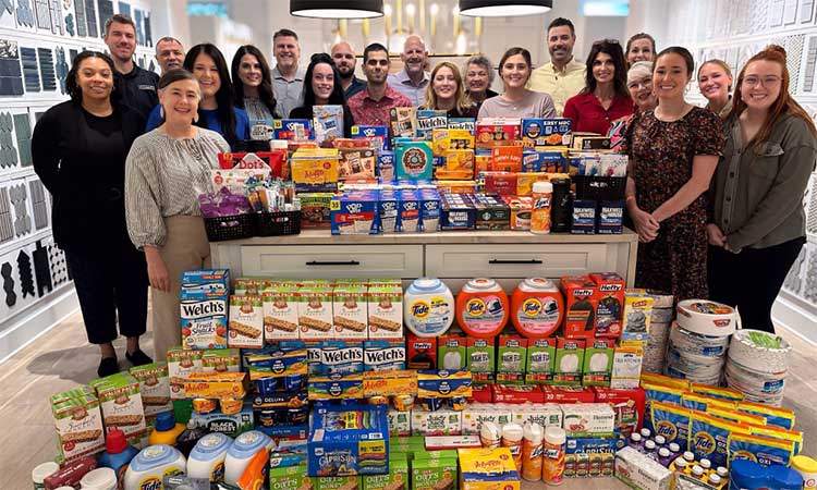David Weekley Homes Team Members standing with donated school supplies